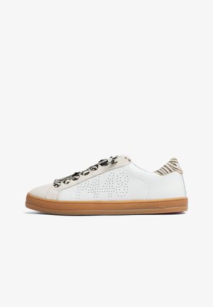 Baskets basses blanches avec semelle en gomme, logo latéral perforé, accents en daim beige, lacets à imprimé zèbre et languette arrière rayée zèbre.