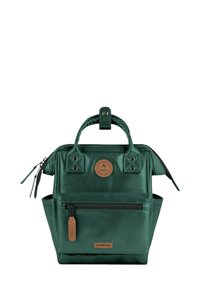 Dunkelgrüne metallische Tasche mit strukturiertem Design, oberen Tragegriffen, einem runden Logo-Patch und frontaler Reißverschlusstasche. Ausgestattet mit eleganten Hardware-Akzenten.