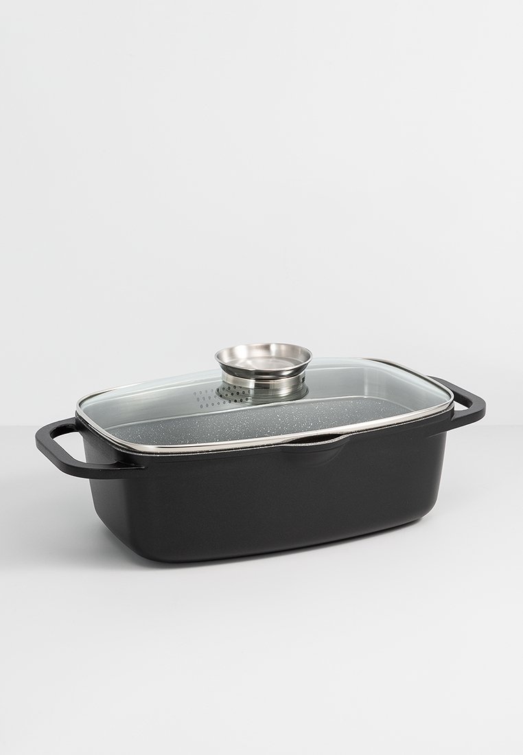 Rechthoekige zwarte kookpan met een doorzichtige glazen deksel en handvat van roestvrij staal. Beschikt over een gestructureerde binnenkant en stoomafvoer.