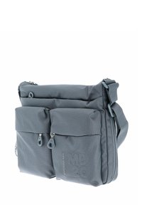 Sac bandoulière en tissu gris avec plusieurs poches zippées, surface texturée et sangle réglable. Présente des logos et des accents de motifs géométriques.