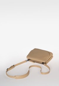 Beige Leder Umhängetasche mit glatter Textur, Reißverschluss und verstellbarem Schultergurt. Sie zeichnet sich durch ein minimalistisches Design und dezente Markenkennzeichnung aus.