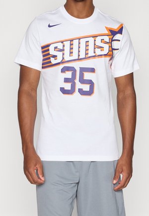 Man wearing white Nike t-shirt with purple-orange Phoenix Suns logo and number 35, paired with gray shorts, cropped at neck and thighs.