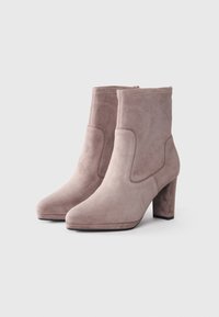 Dusty pink suede ankle boots with a block heel, smooth texture, rounded toe, and stitched detailing along the sides.