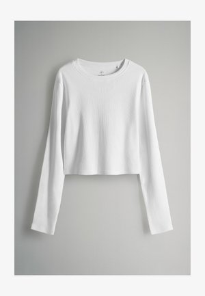 Hvid, langærmet crop top lavet af ribbet stof med en rund halsudskæring. Glat tekstur og ingen synlige mønstre eller accenter.