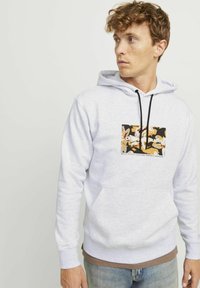 Sudadera gris claro de mezcla de algodón, con un bolsillo tipo canguro en la parte frontal y una impresión gráfica en negro y dorado. Incluye capucha con cordones.