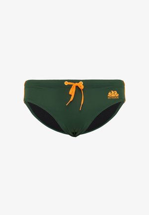 Slip da bagno verde con un laccetto arancione e logo. Il design presenta dettagli neri lungo i lati e un tessuto liscio ed elasticizzato.