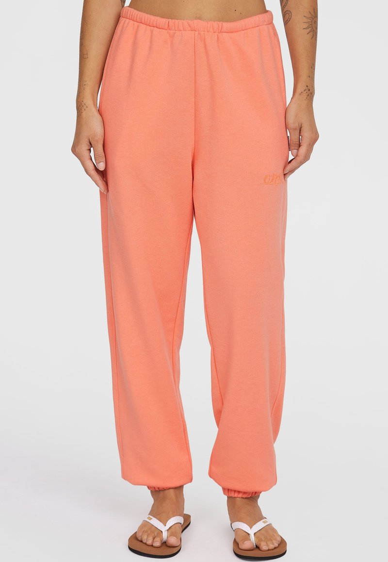 Perzikkleurige sweatpants van zacht materiaal, met een elastische tailleband en taps toelopende boorden. Subtiele logo-detail aan de voorkant.