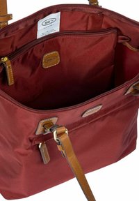 Bordeaux stoffen tas met een gladde textuur, leren accenten en gouden hardware. Beschikt over een geopperde hoofdcompartiment en een binnenvak.