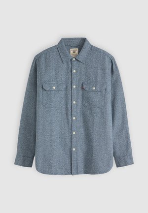 Camisa de manga larga a cuadros azules hecha de un tejido texturizado, con cuello de botón, dos bolsillos en el pecho y botones de color claro.