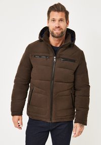Braune gepolsterte Jacke mit Reißverschluss vorne und mehreren Reißverschluss-Taschen. Verfügt über eine Kapuze, ein kontrastierendes Innenfutter, eine strukturierte Oberfläche und Steppdetails.