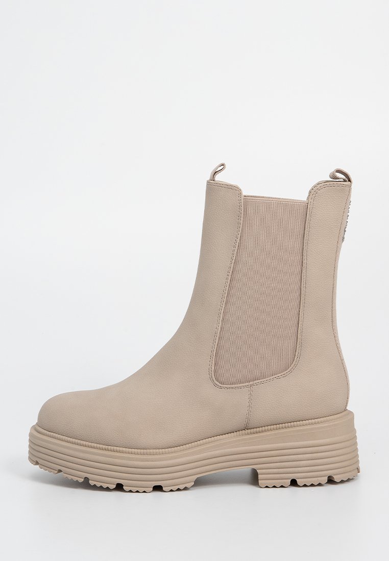 Beige Knöchelstiefel mit elastischen Seitenpaneelen, runder Zehenpartie und dicker gerippter Sohle. Das Obermaterial hat eine glatte, strukturierte Oberfläche.