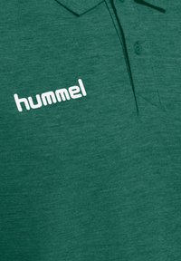 Grøn polo shirt fremstillet af tekstureret stof, med en traditionel krave og et hvidt logo "hummel" på venstre side.