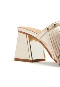 Sandal con tacco a blocco metallico oro, con un tacco lucido decorato in oro, design della cinghia plissettata e texture del tessuto liscia e riflettente.