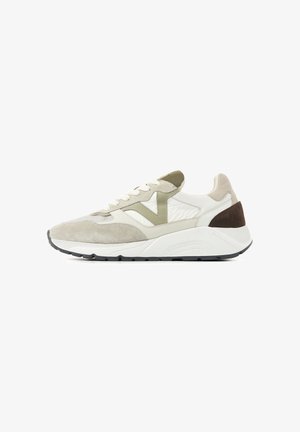 Low-top sneaker in beige, white, olive green, and brown with suede and fabric panels, white thick sole, and lace-up closure on a white background.