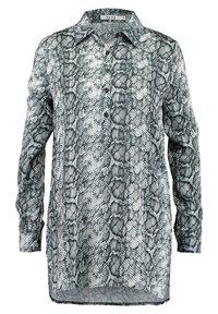 Camicia a maniche lunghe con stampa a serpente in bianco e nero, dotata di collo e bottoni frontali, realizzata in tessuto leggero e semi-trasparente.