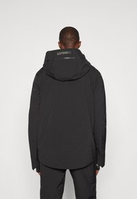 Zwarte waterdichte jas met een hoge kraag en capuchon, voorzien van een subtiele logo op de achterkant en textuurdetail in de stof.
