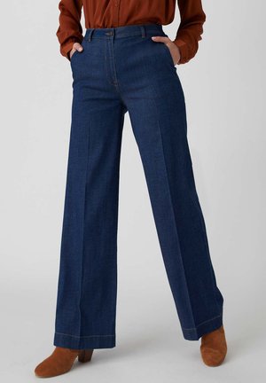 Pantalons en denim bleu foncé à jambes larges avec une taille haute et des poches avant, présentant un design épuré et des détails de couture subtils.