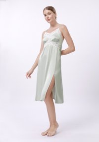 Rochie de noapte din satin de culoare verde pal, cu accente de dantelă, decolteu în V, bretele ajustabile și fanta pe lateral pentru un detaliu suplimentar. Textură netedă pe toată suprafața.