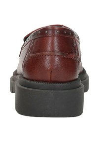 Bruine leren schoenen met een gestructureerde afwerking, rubberen zool en metalen studs langs de bovennaad. Achteraanzicht met details van de hak.