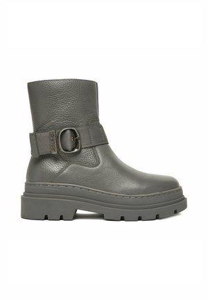 Botín de cuero gris con superficie texturizada, suela gruesa con tacos y correa decorativa ajustable con hebilla metálica redonda.