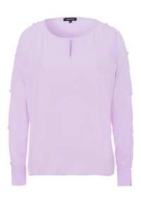 Blusa lunga a maniche con un collo rotondo e un dettaglio a chiave sul davanti di un leggero colore lavanda. Presenta particolari con bottoni sulle maniche. Tessuto liscio.