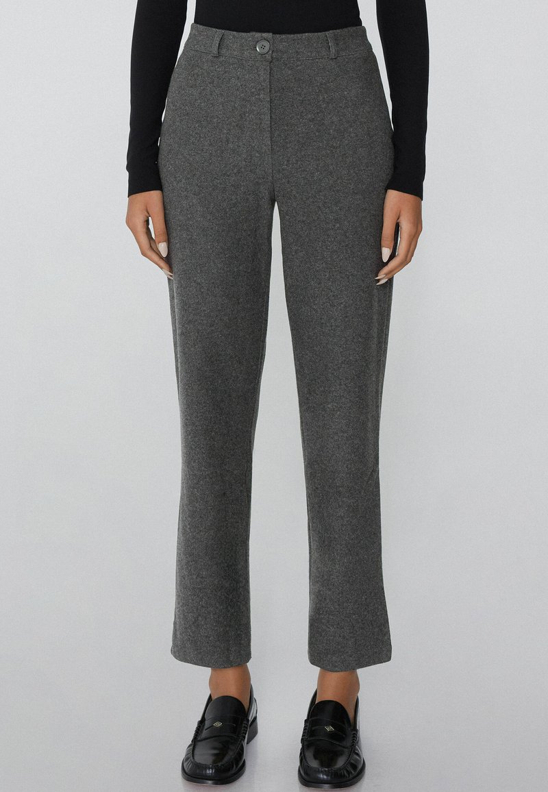 Grijze wollen broek met een rechte snit, voorzien van een voorste knoopsluiting en zijzakken, gestyled met zwarte instappers.