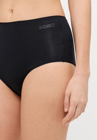 Fekete, magas derekú fehérnemű sima textúrával és diszkrét Borg logóval a derékpánton. Klasszikus forma és varrat nélküli szélek jellemzik.