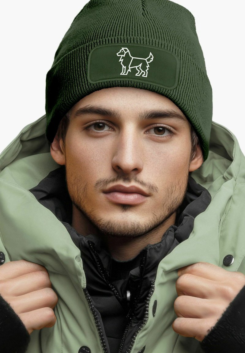 Green knitted beanie with a dog design, paired with a light green puffer jacket and black inner lining, accentuated by a high collar.