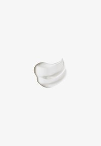 Muestra de crema cosmética blanca cremosa con textura suave y batida sobre fondo blanco liso.