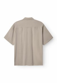 Camicia beige chiara a maniche corte con colletto, realizzata in tessuto liscio. Presenta una piega sul retro e un orlo dritto.