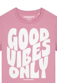 Roze katoenen t-shirt met gedurfde witte tekst "GOOD VIBES ONLY" in een speelse lettertype. Crew neck ontwerp, soepele textuur, relaxte pasvorm.