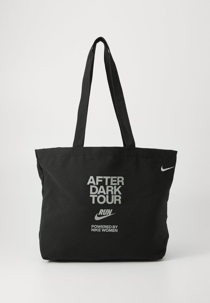 Zwarte canvas draagtas met dubbele handvatten, met witte tekst: "AFTER DARK TOUR," "RUN," en "POWERED BY NIKE WOMEN," plus een Nike-logo.