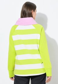 Felpa a strisce verdi e bianche con cappuccio rosa e maniche lunghe, caratterizzata da una vestibilità comoda e polsini elastici. Materiale in cotone liscio.