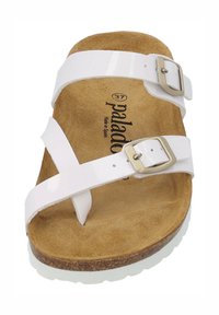 Sandal con cinturini sintetici bianchi e due fibbie regolabili, plantare in faux-suede marrone imbottito e suola in gomma testurizzata.