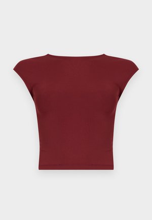 Tamsiai raudonas trumpomis rankovėmis trumpas viršus su plačiu valtine iškirpte ir aptakia siluetu, fonas šviesiai pilkas.