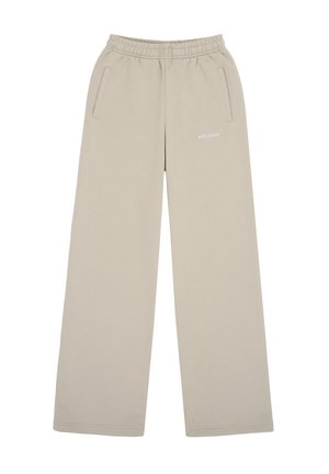Pantaloni beige a gamba larga con elastico in vita, tasche laterali e piccolo logo bianco stampato sulla coscia destra.