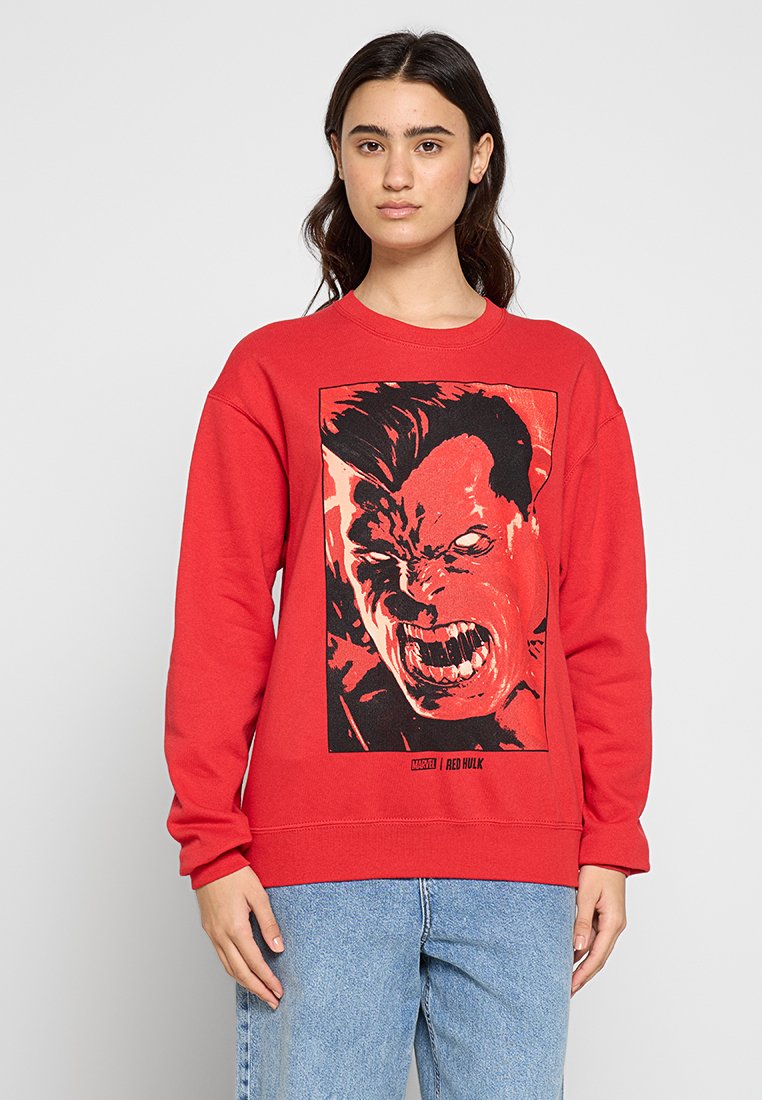 Röd sweatshirt i bomull med ett grafiskt tryck av ett vilt ansikte i svart och rött, med rundad halsringning och ribbade muddar.