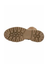 Tan rubber boot sole with thick treads, featuring a zigzag pattern and cross-shaped grips for traction. Smooth texture with reinforced edges.