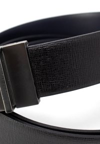 Zwarte textuurriem met een stijlvolle metalen gesp, voorzien van een gladde afwerking. Het materiaal is synthetisch leer met een subtiele nerfstructuur.