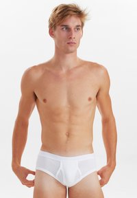 Hvid bomuldsbrief med en tætsiddende design, glat tekstur og en bred taljeelastic. Briefen har paneldetaljer for forbedret støtte.