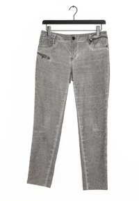 Pantalones de mezclilla gris con textura de estampado de serpiente, que cuentan con un bolsillo con cremallera y bolsillos estándar, colgados en un gancho negro.