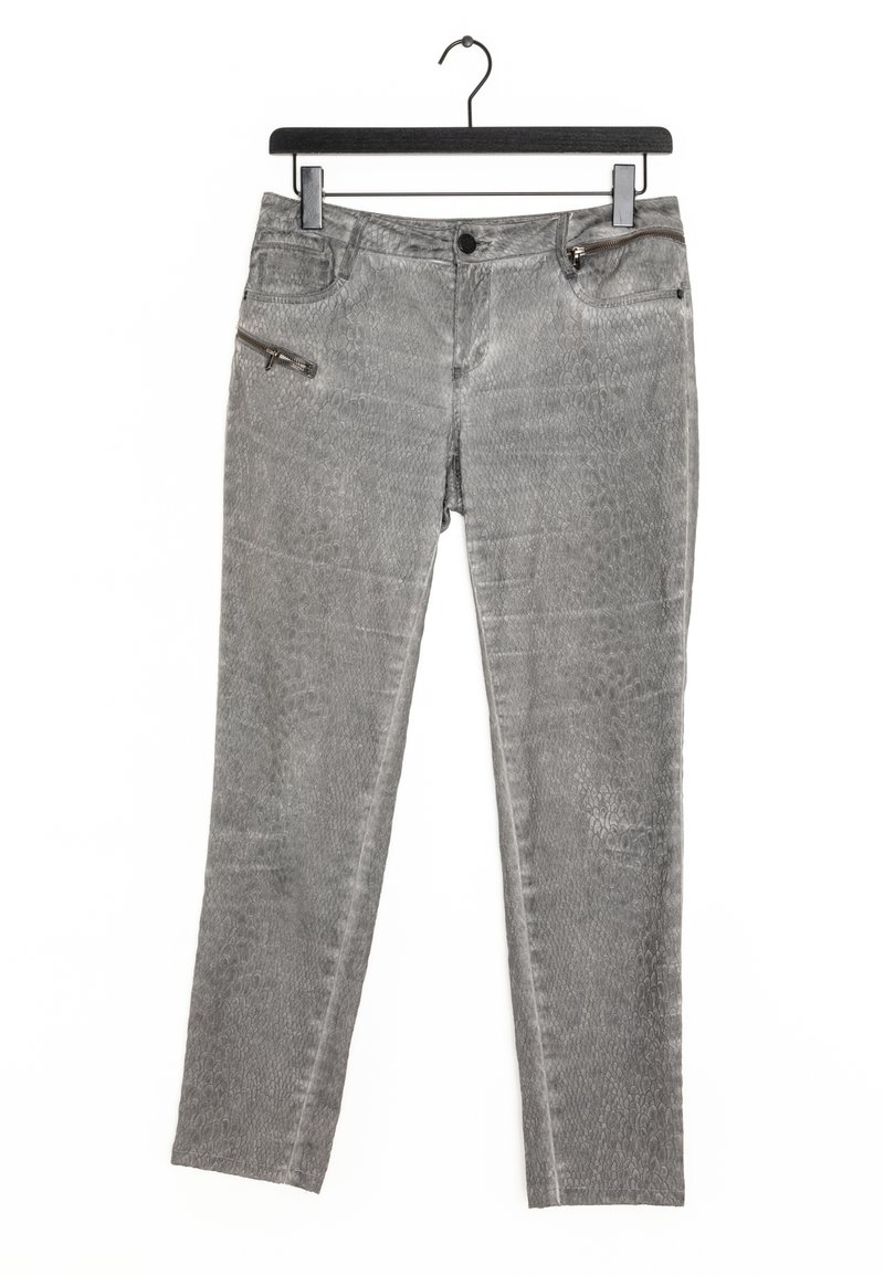 Pantalones de mezclilla gris con textura de estampado de serpiente, que cuentan con un bolsillo con cremallera y bolsillos estándar, colgados en un gancho negro.