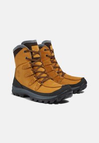 Bottines de randonnée imperméables beiges avec des accents marron, dotées d'un col rembourré, d'œillets en métal et de semelles en caoutchouc texturé pour une meilleure traction.