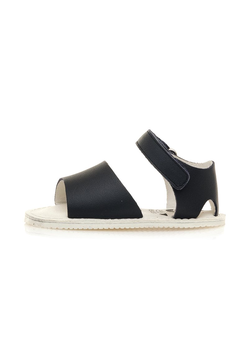 Sandalo in pelle nera con design open toe, cinturino regolabile e suola bianca testurizzata. Costruzione semplice e leggera.
