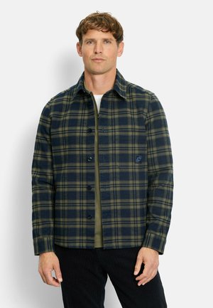 Plaid shirt in navy and green, made of soft fabric with a button front, collar, and a chest pocket featuring a logo patch.
