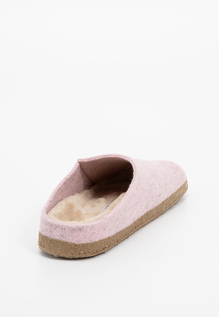 Chausson en feutre de laine rose avec un intérieur doux beige et une semelle en liège naturel, avec un design arrondi et ouvert à l'arrière.