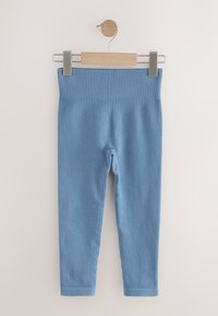 Lyseblå ribstrikkede leggings med bred linning. Hængende på en træclips med metalring. Glat tekstur og tætsiddende ankeludformning.