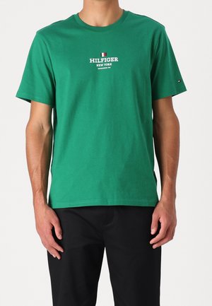 Green cotton t-shirt featuring a round neck and short sleeves, with "HILFIGER" and "NEW YORK" text in white, plus a small logo detail.