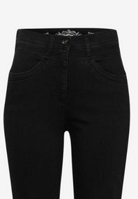 Czarne dżinsy o wysokim stanie, z kieszeniami z przodu, zapięciem na guzik i subtelnymi przeszyciami na pasku.