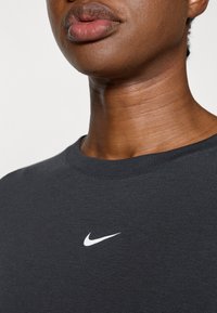 Μαύρη βαμβακερή φούτερ μπλούζα με στρογγυλή λαιμόκοψη και μικρό λευκό λογότυπο Nike στο στήθος, λεία υφή και ριμπ μανσ�έτες.